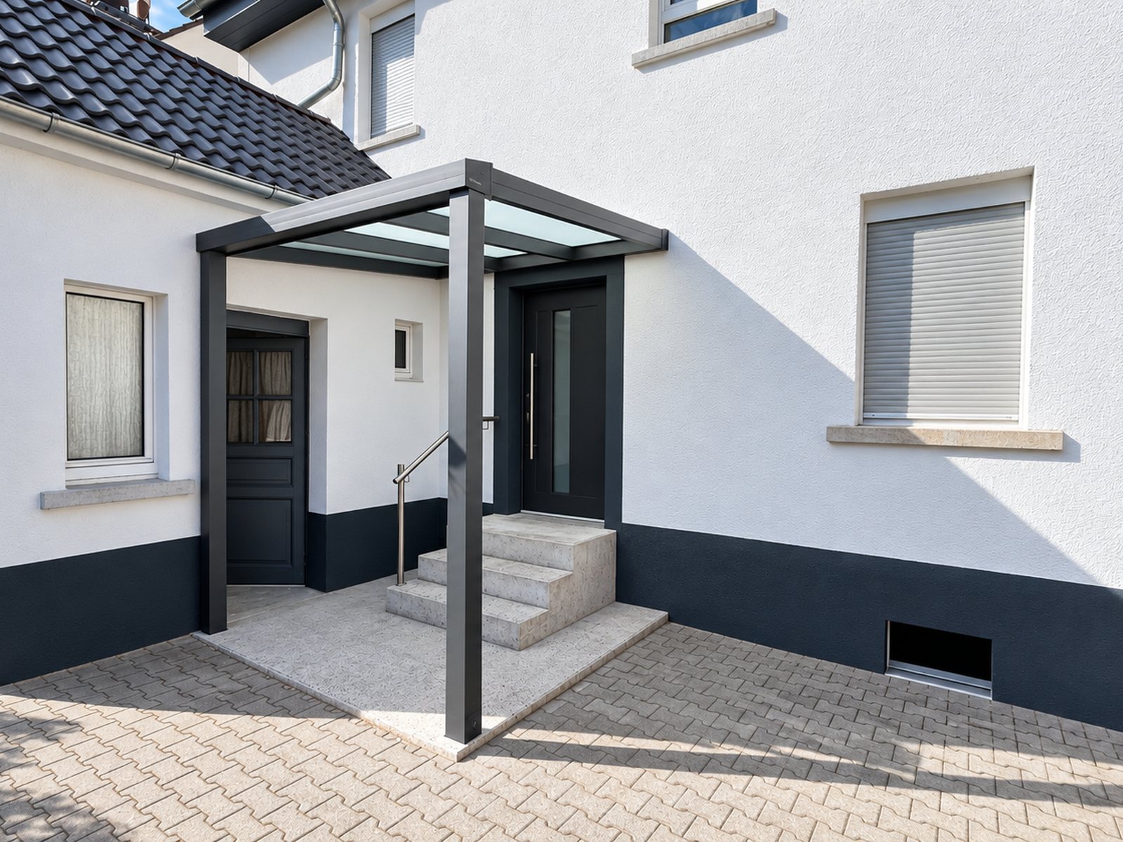Eingangsüberdachung TRENDLINE mit Stützen vor einer Haustür mit Treppe – Beispielansicht